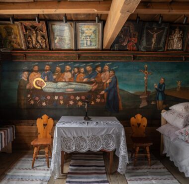 Malowane drewniane wnętrze ze stolikiem przykrytym koronkowym obrusem (wnętrze chałupy Anny Doruli w Szaflarach)
