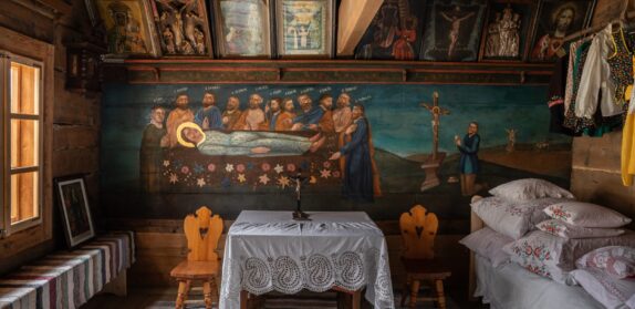 Malowane drewniane wnętrze ze stolikiem przykrytym koronkowym obrusem (wnętrze chałupy Anny Doruli w Szaflarach)