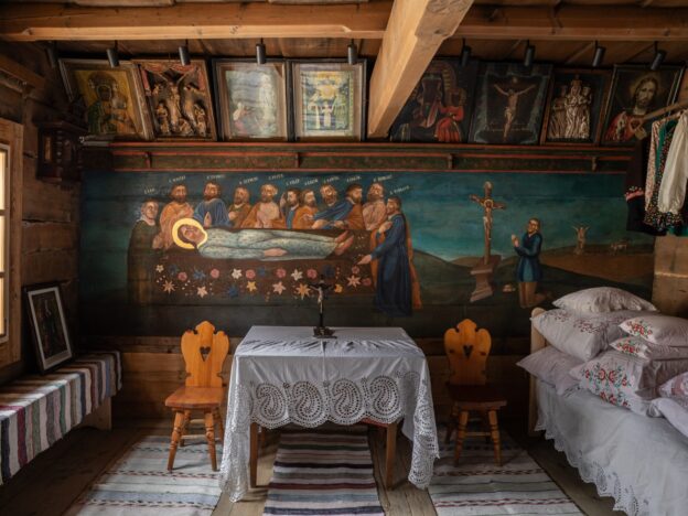 Malowane drewniane wnętrze ze stolikiem przykrytym koronkowym obrusem (wnętrze chałupy Anny Doruli w Szaflarach)