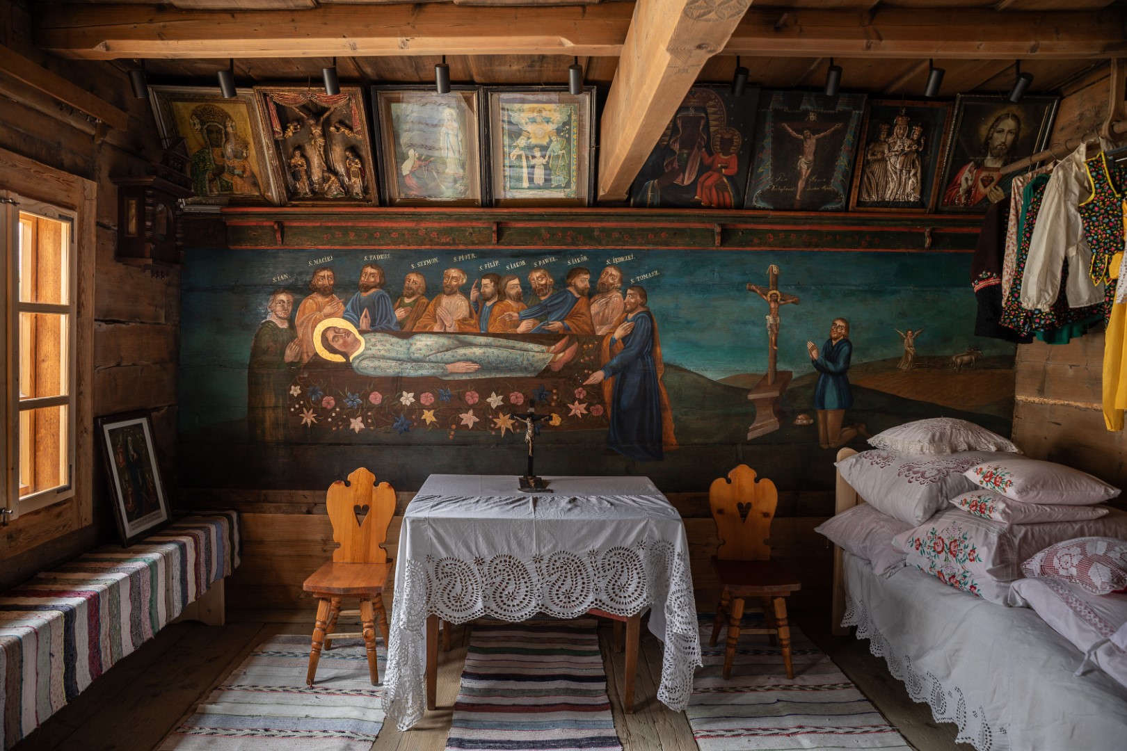 Malowane drewniane wnętrze ze stolikiem przykrytym koronkowym obrusem (wnętrze chałupy Anny Doruli w Szaflarach)